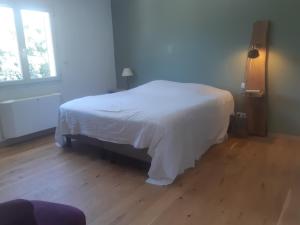 Schlafzimmer mit einem weißen Bett und Holzboden in der Unterkunft Grande maison familiale avec piscine proche Avignon in Bagnols-sur-Cèze