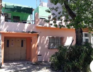un edificio naranja con un árbol delante de él en Depto a una cuadra de costanera Gualeguaychú hta 4 personas en Gualeguaychú