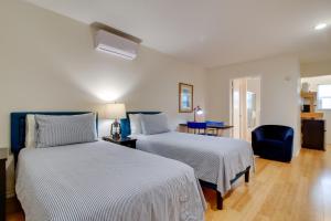 a bedroom with two beds and a blue chair at Tranquil Rancho Viego Studio, 29 Mi to Beach in Los Fresnos
