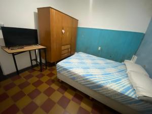 Schlafzimmer mit einem Bett und einem Schreibtisch mit einem Computer in der Unterkunft Depto a una cuadra de costanera Gualeguaychú hta 4 personas in Gualeguaychú