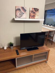 TV de pantalla plana sobre una mesa de madera en Saunallinen rivitalokaksio Varkaudessa, en Varkaus