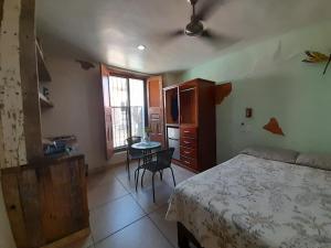 a bedroom with a bed and a table and a kitchen at Aguacate Suites in Mazatlán