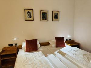 two beds in a room with pictures on the wall at Hotel Nest in Berlin