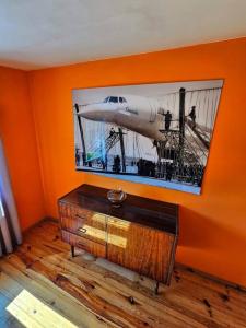 ein orangefarbenes Zimmer mit einem Bild eines Flugzeugs an der Wand in der Unterkunft Dom letniskowy przy lesie nad jeziorem in Rogowo