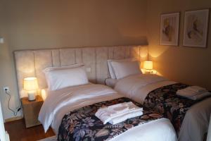 um quarto com 2 camas com lençóis brancos e toalhas em Daphne Luxury Apartment em Kastoria
