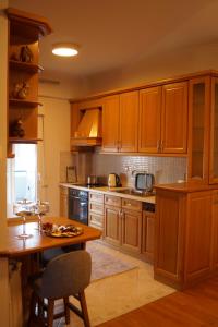 a kitchen with wooden cabinets and a wooden table at Daphne Luxury Apartment in Kastoria