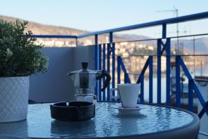 una mesa con cafetera y una taza en el balcón en Daphne Luxury Apartment, en Kastoria