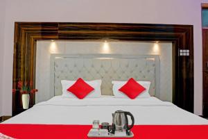 a bedroom with a bed with red pillows at Goroomgo Luxury JSB Palace Varanasi in Varanasi