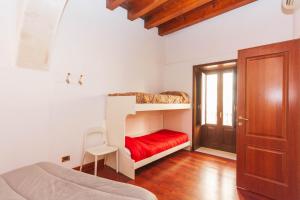 a bedroom with a bunk bed with a red blanket at Talete Palace in Siracusa