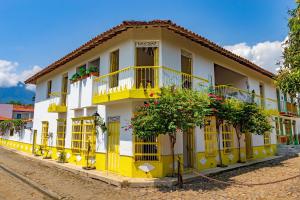 un edificio amarillo y blanco con puertas y balcones amarillos en Hotel Cauca Viejo Fundadores en Jericó