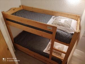 Ce lit superposé en bois se trouve dans un dortoir. dans l'établissement RISOUL Altaïr Jolie T2 confortable skis aux pieds, à Risoul