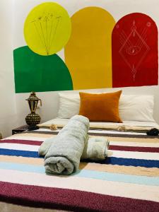 una camera da letto con un letto con dipinti colorati alle pareti di Art studio mazighen a El Jadida Altre 22 foto