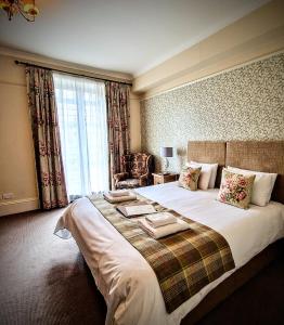a bedroom with a large bed with a large window at George Hotel & Granary in Frome