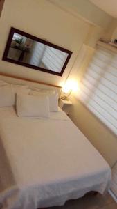 ein Schlafzimmer mit einem weißen Bett und einem Fenster in der Unterkunft The SPLENDOR comfortable living by Awsom Phil in Manila