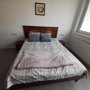 a bedroom with a large bed with a wooden headboard at Demizson Panzió in Kehidakustány