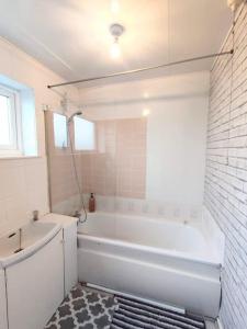 Baño blanco con bañera y lavamanos en Golden Palace. Free Parking, en North Tyneside