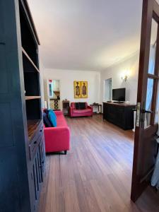 馬貝拉的住宿－Casa Adelfa，客厅配有红色沙发和电视