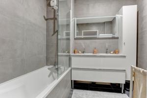 La salle de bains est pourvue d'une douche, d'une baignoire et d'un lavabo. dans l'établissement Le tocqueville - Versailles, à Versailles