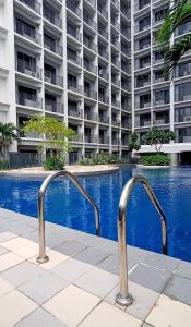 einem Pool vor einem großen Apartmenthaus in der Unterkunft The SPLENDOR comfortable living by Awsom Phil in Manila