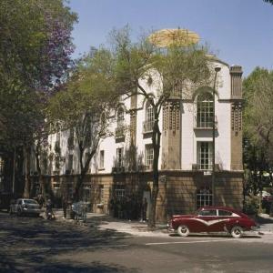 Un coche rojo aparcado delante de un edificio en HABITACIONES EN EXCELENTE UBICACIÓN PARA 8 PERSONAS, en Ciudad de México