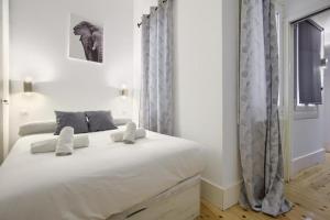 una camera con un grande letto bianco di Charming Madrid Embajadores - Estancias Temporales a Madrid