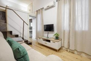 een woonkamer met een bank en een televisie bij Charming Madrid Embajadores - Estancias Temporales in Madrid