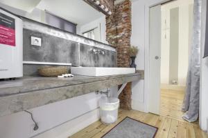 a bathroom with a sink and a brick wall at Charming Madrid Embajadores - Estancias Temporales in Madrid