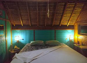 a bed in a blue room with two lamps at UTOPIA BUNGALOWS in Gili Air