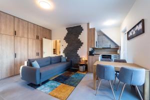 a living room with a blue couch and a table at Apartmány u Sjezdovky in Pernink