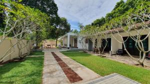 a backyard of a house with a lawn and trees at Coastal Villa Mirissa in Mirissa