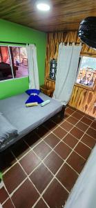 Cama en habitación con paredes verdes en Sierra Minca SEDE II, en Arimaca