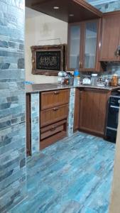 uma cozinha com armários de madeira e piso em azulejo azul em شقه no Cairo