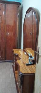 uma mesa de madeira e cadeira num quarto em شقه no Cairo