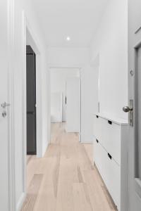 um quarto branco com armários brancos e piso em madeira em Modern Central Located Apartment em Copenhague