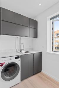 a kitchen with a washing machine and a sink at Modern Central Located Apartment in Copenhagen