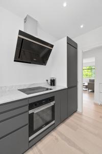 uma cozinha com armários pretos e um fogão em Modern Central Located Apartment em Copenhague