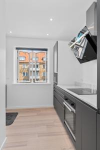 uma cozinha com balcões a preto e branco e uma janela em Modern Central Located Apartment em Copenhague