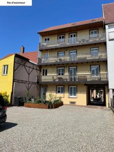 - un grand bâtiment avec un balcon en haut dans l'établissement Appartements centre ville Colmar 4 familles, à Colmar