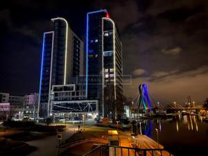 due edifici alti in una città di notte di Apartament River Towers a Bydgoszcz