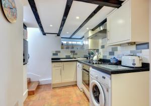 a kitchen with a washer and dryer in it at Bosuns Cottage in Torquay