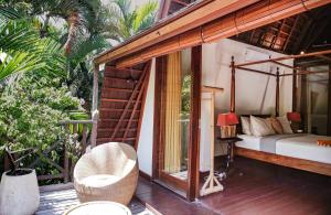 a room with a bed and a bed and a balcony at Villa Hangat in Seminyak