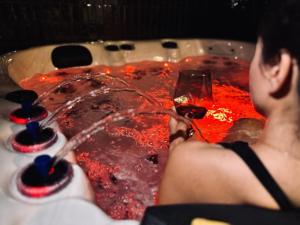a man holding a glass of wine in a hot tub at Jacuzzi Loft & Sauna Sanctuary in Katowice