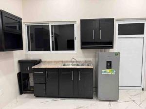 een keuken met een spoelbak en een koelkast bij Apartamento confortable y bien ubicado in Santa Cruz Huatulco