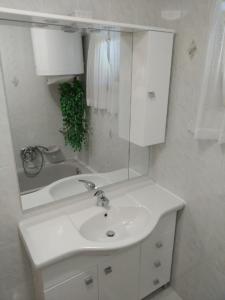 a white bathroom with a sink and a mirror at Üttörő út 177 B in Balatonfenyves