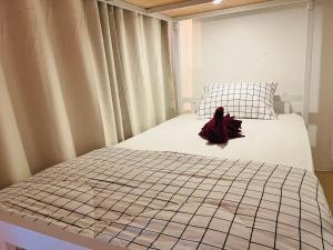 1 dormitorio con 1 cama con sombrero rojo en Jasper Phangan Hostel, en Thong Sala