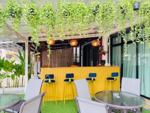 un patio con mesas, sillas y plantas en Jasper Phangan Hostel, en Thong Sala