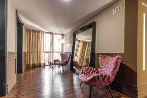 uma sala de estar com duas cadeiras e um espelho em Gran Villagio Hotel SP by Castelo Itaipava em São Paulo