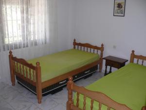 two beds with green sheets in a room at Casa d'Or in L'Estartit