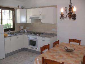 a kitchen with white cabinets and a table with a bowl on it at Casa d'Or in L'Estartit