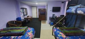 Kupi-Kupi & Stay في Kampong Kundassan: غرفة بسريرين بطابقين وغرفة معيشة